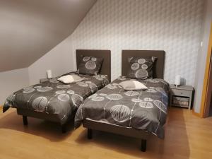 two beds sitting next to each other in a bedroom at Gîte De L'Oie Blanche in Blodelsheim