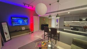 a kitchen with a bar with pink and purple lighting at Century Stay by Bait Zain in As Sīfah