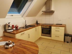 a kitchen with a sink and a table and a window at Gîte De L'Oie Blanche in Blodelsheim