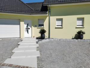 a house with a white garage door and a driveway at Gîte De L'Oie Blanche in Blodelsheim