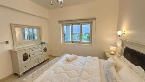 a bedroom with a large white bed and a window at Century Stay by Bait Zain in As Sīfah +14 photos