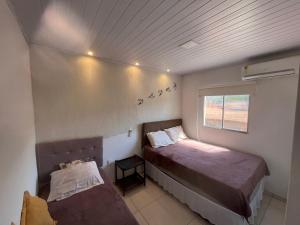 a small bedroom with two beds and a window at Casa paraíso dos milagres in São Miguel dos Milagres