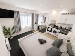 a living room with a couch and a kitchen at The Studio Room in Brentwood
