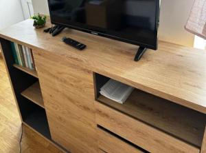 a wooden entertainment center with a flat screen tv at Sošice Garden Apartments in Sošice