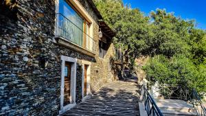 a stone building with a staircase next to a building at Aguilhões River House in Pedorido