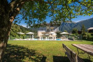a view of a resort with a bench and a pool at Recidence EMILIO in Ledro