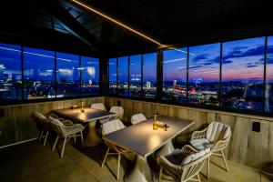 a restaurant with two tables and chairs and windows at Elitte Inn & Suites in Bucharest