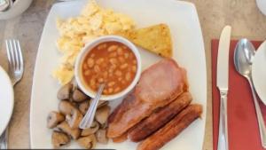 a white plate of food with sausage beans and mushrooms at The Fernroyd in Blackpool