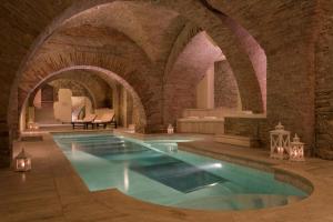 an indoor swimming pool with an archway in a building at Sina Brufani in Perugia