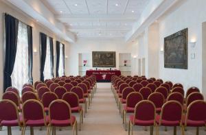 an empty room with red chairs and a podium at Sina Brufani in Perugia +37 photos