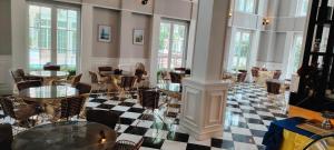 a lobby with tables and chairs on a checkered floor at Pattaya Private Beach - Grand Florida Beachfront Condo Resort in Na Jomtien