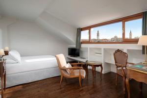 a hotel room with a bed and a desk and chairs at Sina Maria Luigia in Parma