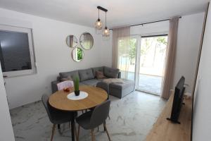 a living room with a table and a couch at Holiday Home Paradise in Prozor