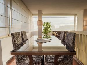 a dining room table with chairs and a plant on it at Hotel Sina Astor in Viareggio