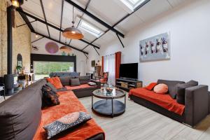 a living room with two couches and a table at Gîte La Ferme Du Mesnil in Sevremont