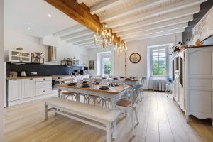 a kitchen with a table and chairs in a room at Gîte La Ferme Du Mesnil in Sevremont