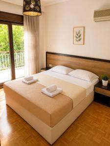 a bedroom with a large bed with two towels on it at Nickolas Sea View Apartment in Paleo Tsifliki