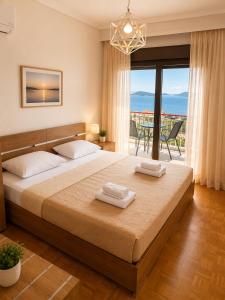 a bedroom with a large bed with two towels on it at Nickolas Sea View Apartment in Paleo Tsifliki