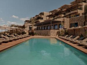 a swimming pool with lounge chairs and a hotel at OKU Bodrum in Golturkbuku