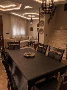 a dining room with a table and chairs and a couch at Azra Luxe villa famille uniquement Family only in Saïdia