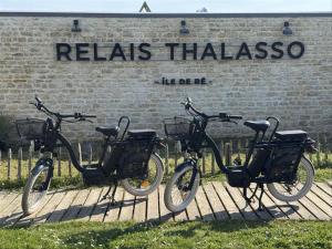 three bikes are parked in front of a sign at Hôtel Atalante - Relais Thalasso & Spa in Sainte-Marie-de-Ré