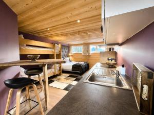 a kitchen with a sink and a bed in a room at Résidence Bel Air, Univers Fantastique in Montriond