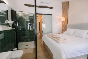 a bedroom with a white bed and a glass shower at Casita Capricho in Zuheros +35 photos