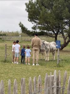 a group of children standing around a man looking at animals at Hôtel Atalante - Relais Thalasso & Spa in Sainte-Marie-de-Ré