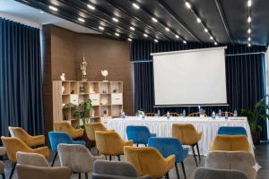 a room with a table and chairs and a projection screen at Hotel Alion21 in Durrës +58 photos