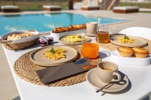 a table with breakfast foods and drinks and a pool at Agriturismo Agricola Chiani in Melendugno