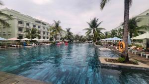 a large swimming pool in a resort with palm trees at Viona Beach Hotel - Marina Phu Quoc in Phú Quốc