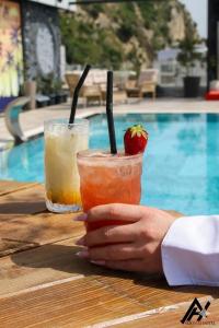 two cocktails sitting on a table next to a pool at Hotel Alion21 in Durrës