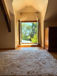 an empty room with a large window and a rug at The Cherries Houehdeu in Naizin