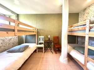 a bedroom with two bunk beds and a desk at La Bastide en Margeride in Châteauneuf-de-Randon