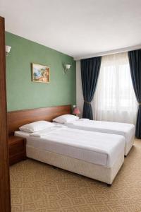 a bedroom with two beds and a window at Gyumri Hotel in Gyumri +12 photos