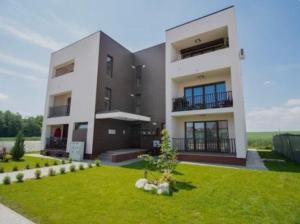 a large house with a green lawn in front of it at Magnolia Residence Premium in Găgeni