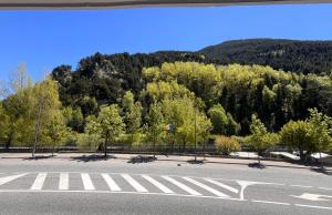 an empty parking lot with trees and a mountain at AC Apartaments Comapedrosa Canillo in Canillo