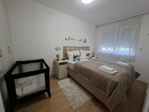a bedroom with a large bed and a window at Apartman TRI KRALJA 4 in Banja Koviljača