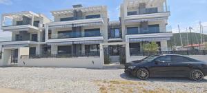 a black car parked in front of a building at Marine Apartment in Nea Peramos