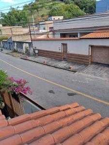 an empty street next to a white building with red roofs at Canto dos pássaros in Volta Redonda +3 photos