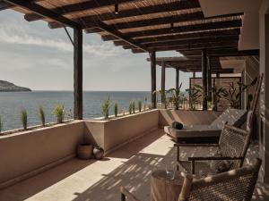 a balcony with chairs and a view of the ocean at OKU Bodrum in Golturkbuku