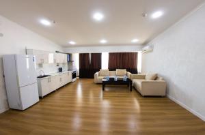 a kitchen and a living room with a couch and a refrigerator at Avenue Hotel Tashkent in Tashkent +25 photos