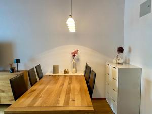 a dining room table with chairs and a vase with flowers at Haus Anemona in Savognin
