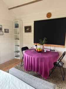 a table with a purple table cloth and a tv at Sportfiskestugan in Färjestaden