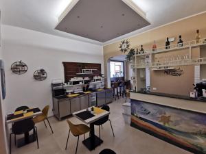 a kitchen with a counter and some chairs and tables at Il Giardino del Sol in San Vito lo Capo