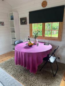 a purple table with a bowl of fruit on it at Sportfiskestugan in Färjestaden +8 photos