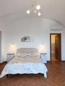 a white bedroom with a bed and two tables at Villa Gea in Praiano +59 photos