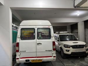 two white vans parked in a parking lot at Odranest Serviced Apartment in Secunderabad