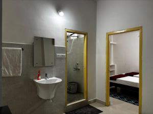 a bathroom with a sink and a mirror and a bed at Odranest Serviced Apartment in Secunderabad