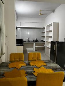 a room with a table and two chairs and a kitchen at Odranest Serviced Apartment in Secunderabad